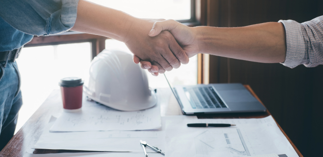 a construction meeting with two people shaking hands